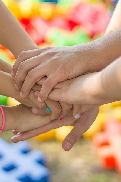 Kinderfreundliche Gastronomie im Oberallgäu - Gruppe von Kindern halten zusammen die Hände aufeinander