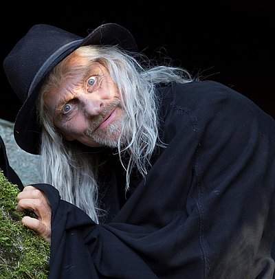 Luisenburg Festspiele im Fichtelgebirge Luisenburg Festspiele im Fichtelgebirge - Mann mit grauen Haaren im schwarzen Hexerkostüm schaut in die Kamera